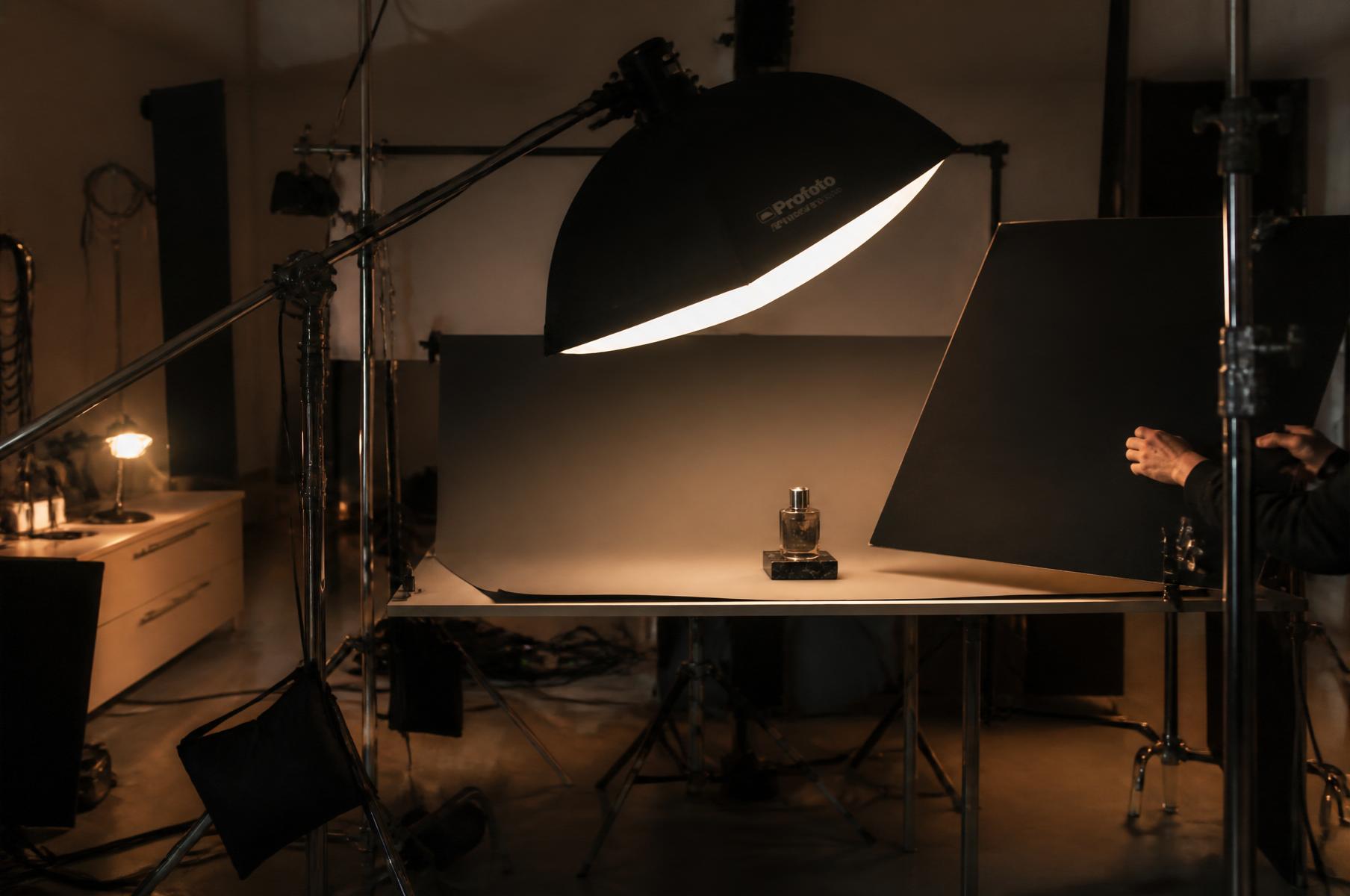 Backstage dello studio: softbox su braccio, set di still life, bandiere nere